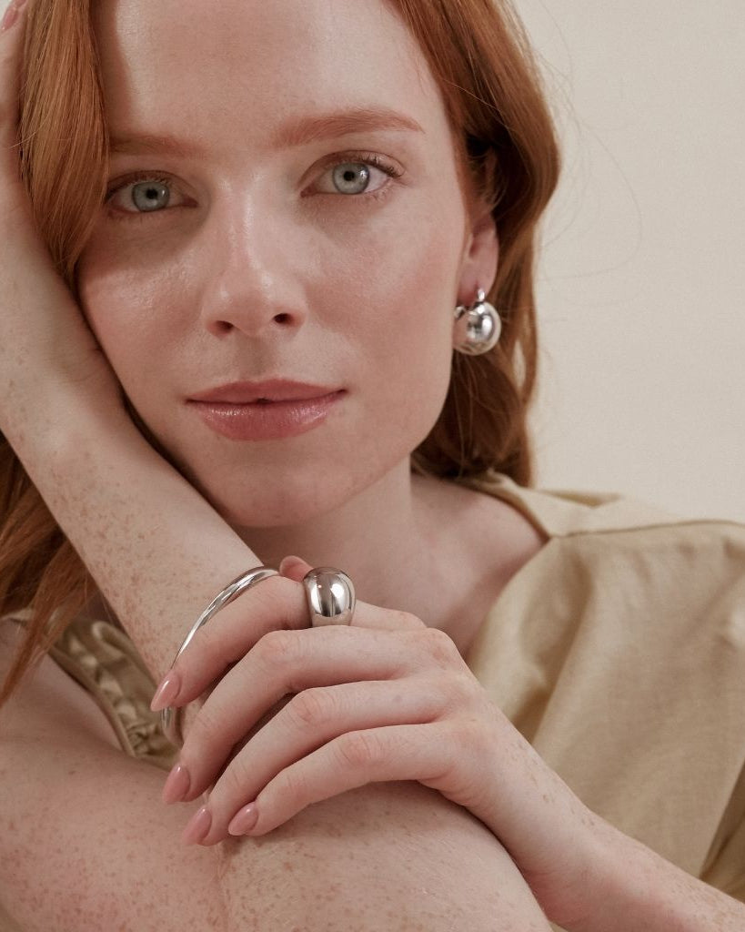 Model wearing Maudella silver-tone earrings, bangle and ring